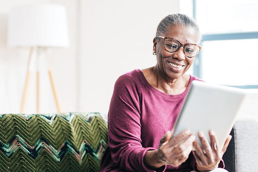 Senior woman reading COVID-19 information on her tablet