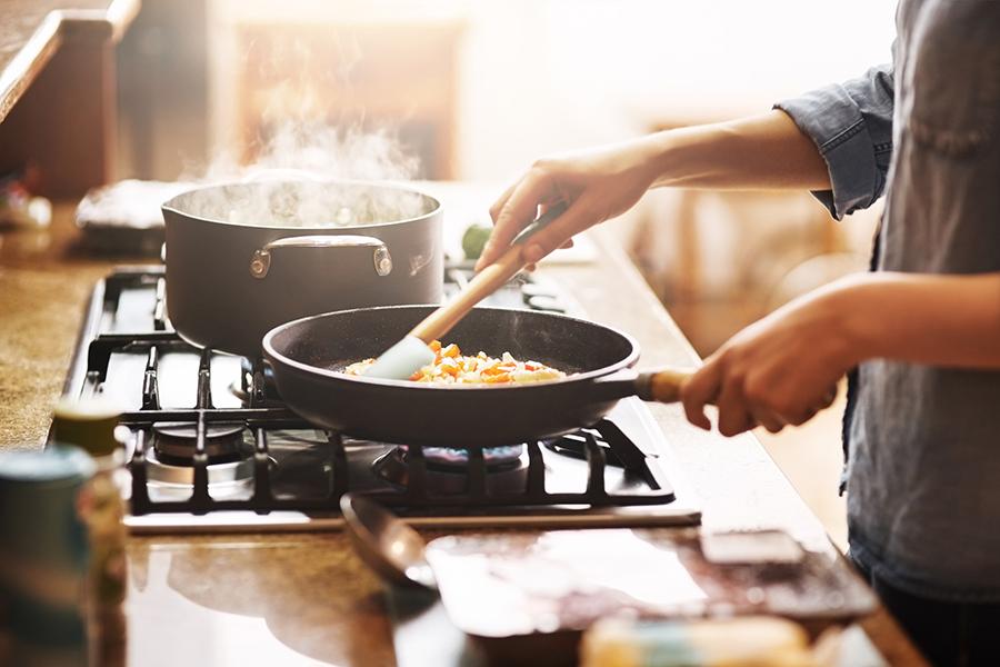 Woman cooking healthy recipe on stove