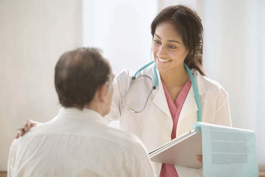 Female doctor talking with patient while holding a clipboard