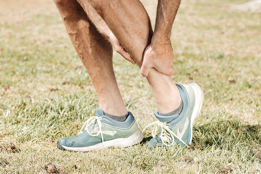 Man holding his lower leg in pain