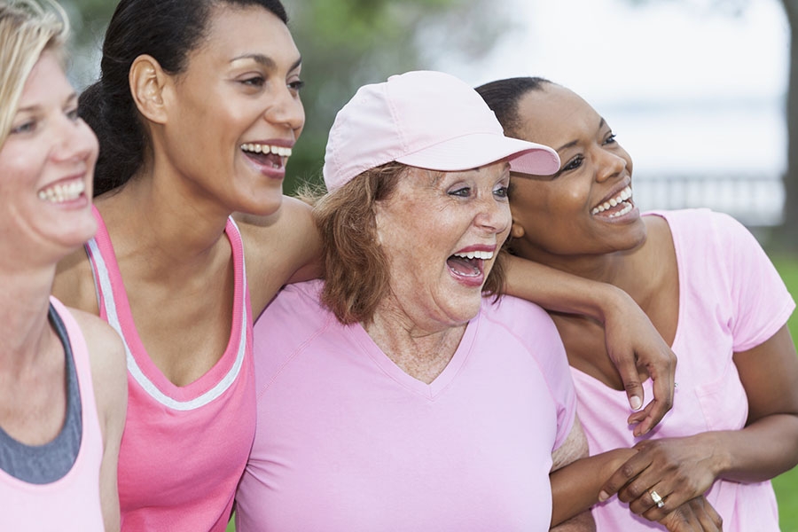 Women in pink with arms around each other 