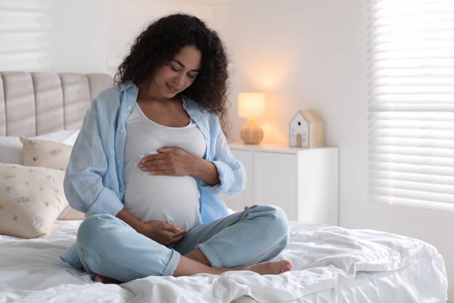 A soon-to-be mother gently cradling her belly.