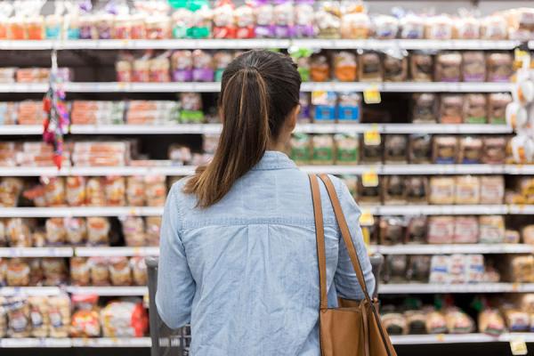 Woman browing food in grocery store aisle