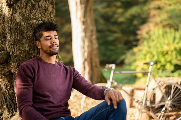 Young man resting outside, managing his stress and anxiety